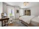 Bedroom featuring a crystal chandelier, hardwood floors, natural light and neutral-toned decor at 11277 Serenbe Ln, Chattahoochee Hills, GA 30268