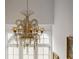 View of a decorative chandelier in a room with tall windows, offering a luxurious and elegant touch at 11277 Serenbe Ln, Chattahoochee Hills, GA 30268