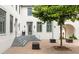 A view of the courtyard featuring a brick surface, gray steps, modern seating cubes, mature trees and building entrance at 11277 Serenbe Ln, Chattahoochee Hills, GA 30268