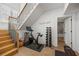 Basement exercise area featuring workout equipment and stairs, illuminated by natural light at 11277 Serenbe Ln, Chattahoochee Hills, GA 30268