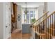 View from staircase, overlooking kitchen with custom cabinets, large picture window, and an island with seating at 11277 Serenbe Ln, Chattahoochee Hills, GA 30268