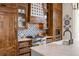 Close-up of gourmet kitchen with tiled backsplash, stainless steel appliances, and custom cabinetry at 11277 Serenbe Ln, Chattahoochee Hills, GA 30268