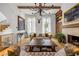 Beautiful living room with stylish sofas, a fireplace, hardwood floors, and an elegant chandelier at 11277 Serenbe Ln, Chattahoochee Hills, GA 30268