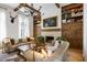 Elegant living room featuring hardwood floors, exposed beams, a fireplace, and custom built-in bookshelves at 11277 Serenbe Ln, Chattahoochee Hills, GA 30268