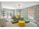 Bright room with floral wallpaper, green modular couch, and French doors leading to the backyard at 11277 Serenbe Ln, Chattahoochee Hills, GA 30268