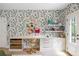 Beautiful built-in desk and shelving in a room with floral wallpaper and a backyard view at 11277 Serenbe Ln, Chattahoochee Hills, GA 30268