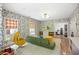 Spacious room with floral wallpaper, a green sofa, a yellow chair, and a doorway to the gym at 11277 Serenbe Ln, Chattahoochee Hills, GA 30268