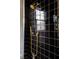 This shower stall is finished in black tile and accented with gold plumbing fixtures at 11277 Serenbe Ln, Chattahoochee Hills, GA 30268