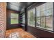 Bright sun room with brick accent wall, windows and tile floors with modern black trim at 1383 Fenway Cir, Decatur, GA 30030