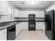 Functional kitchen featuring white cabinets, black appliances, dark countertops, and neutral flooring at 3732 Landgraf Cv, Decatur, GA 30034