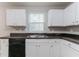 Well-lit kitchen features a stainless steel sink, dark countertops, and ample white cabinets at 3732 Landgraf Cv, Decatur, GA 30034
