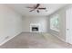 Spacious living room with neutral carpet, ceiling fan, fireplace, and a bright window offering natural light at 3732 Landgraf Cv, Decatur, GA 30034