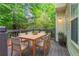 Outdoor deck with table, chairs, and a lush view of the surrounding foliage at 3732 Landgraf Cv, Decatur, GA 30034