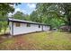 Spacious backyard view with lush greenery, a white brick house, and wooded surroundings at 4651 Palm Dr, Douglasville, GA 30135
