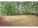 Spacious backyard with mature trees and partially cleared areas, offering potential for outdoor activities at 4651 Palm Dr, Douglasville, GA 30135