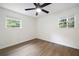 Cozy bedroom with hardwood flooring, a ceiling fan, and two windows for ample sunlight at 4651 Palm Dr, Douglasville, GA 30135