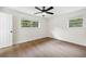Bright bedroom featuring hardwood floors, neutral walls, a ceiling fan, and two windows at 4651 Palm Dr, Douglasville, GA 30135