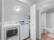 Practical laundry area with modern washer, dryer, and adjacent bathroom space at 1062 Sasha Ln, Roswell, GA 30075