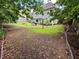 Large backyard with mature trees, seating area, and a view of the home's exterior at 25 Jessamine Trail Trl, Lawrenceville, GA 30046