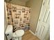 Bathroom with white door and beige walls, showcasing a toilet and a lighthouse-themed shower curtain at 25 Jessamine Trail Trl, Lawrenceville, GA 30046