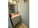Powder room featuring coastal-themed decor, vanity with storage, and neutral tile flooring at 25 Jessamine Trail Trl, Lawrenceville, GA 30046