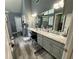 Primary bathroom featuring dual vanities, gray cabinets, lots of counter space, and a large mirror at 25 Jessamine Trail Trl, Lawrenceville, GA 30046