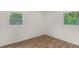 Cozy bedroom featuring wood-look floors and bright windows with views of the surrounding trees at 3181 Pennington Sw Cir, Atlanta, GA 30354