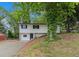 Charming home with white exterior and black shutters sits on a hill surrounded by mature trees at 3181 Pennington Sw Cir, Atlanta, GA 30354
