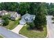 Aerial view of a suburban home, showcasing its position in the neighborhood with a long driveway and mature trees at 1005 Wellers Ct, Roswell, GA 30076