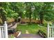 Backyard with green grass, flowerbed, patio furniture, and partial fence at 1005 Wellers Ct, Roswell, GA 30076
