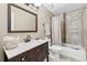 Neutral bathroom features a dark vanity with a white countertop and a shower-tub with a tile surround at 1005 Wellers Ct, Roswell, GA 30076