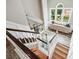 Bright, open staircase featuring hardwood steps and wainscotting with large windows at 1005 Wellers Ct, Roswell, GA 30076
