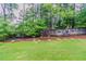 Expansive backyard featuring a manicured lawn, mature trees, and a wooden fence at 1115 Hunters Creek Ct, Lawrenceville, GA 30043