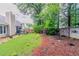 Large backyard with green lawn, planting area, established trees and a wooden perimeter fence at 1115 Hunters Creek Ct, Lawrenceville, GA 30043