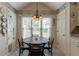 Cozy breakfast nook features a round table with chandelier, natural light, and charming wallpaper at 1115 Hunters Creek Ct, Lawrenceville, GA 30043