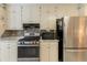 Updated kitchen with white cabinets, stainless steel appliances, and a mosaic backsplash at 1115 Hunters Creek Ct, Lawrenceville, GA 30043