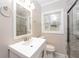 This updated bathroom features a bright vanity, a glass shower, and marble tiling at 1381 Benteen Way Southeast, Atlanta, GA 30315