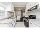 Renovated kitchen with white cabinets, granite countertops, stainless steel appliances, and hardwood floors at 1381 Benteen Way Southeast, Atlanta, GA 30315