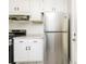 Kitchen with stainless steel refrigerator, white cabinets, granite countertops and black gas range at 1381 Benteen Way Southeast, Atlanta, GA 30315