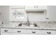 Close up of granite countertops, stainless steel sink, and white cabinets in a brightly lit kitchen at 1381 Benteen Way Southeast, Atlanta, GA 30315
