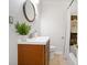 This bathroom offers a wooden vanity and decorative oval mirror at 1398 Woodland Ave, Atlanta, GA 30316