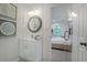 Bathroom showcasing modern white vanity, mirror, shower with glass door, and unique wall art at 1398 Woodland Ave, Atlanta, GA 30316