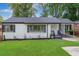 Charming, updated home with white brick, dark shutters, covered carport, and fresh landscaping at 1398 Woodland Ave, Atlanta, GA 30316