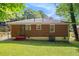 Exterior view of a one story brick home with green lawn in the backyard and windows on the side at 2329 Polar Rock Sw Ave, Atlanta, GA 30315