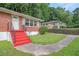 Inviting red-stair entryway to a charming brick home with a well-manicured lawn and mature trees at 2329 Polar Rock Sw Ave, Atlanta, GA 30315