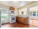 Efficient kitchen with wood cabinets, a white stove, microwave, and hardwood floors adjacent to the living room at 2329 Polar Rock Sw Ave, Atlanta, GA 30315