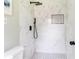 Modern shower with white marble tile, black fixtures, and a built-in shampoo nook with black and white mosaic tile at 2343 Dawn Dr, Decatur, GA 30032