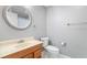 Well-lit bathroom featuring a round mirror, toilet, and light wood vanity at 2717 Hearthstone Cir, Marietta, GA 30062