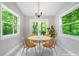 Sun-drenched dining area with modern chandelier, stylish furniture, and expansive windows overlooking the backyard at 2717 Hearthstone Cir, Marietta, GA 30062