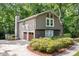 Rear exterior featuring a two-car garage, stone accents, neutral siding, and a chimney at 2717 Hearthstone Cir, Marietta, GA 30062